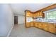 Eat-in kitchen with knotty pine cabinets, tiled backsplash, and updated flooring at 1209 Landon St, Durham, NC 27703