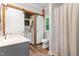 Bathroom with stackable washer/dryer, warm wood look floor, and shower/tub at 1398 Tarboro Rd, Youngsville, NC 27596