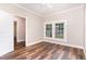 Bedroom featuring wood floors, white trim, and two windows offering natural light at 1398 Tarboro Rd, Youngsville, NC 27596