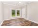 Bedroom featuring wood floors, and two windows with a view of the backyard at 1398 Tarboro Rd, Youngsville, NC 27596