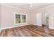 Spacious bedroom with wood floors, white trim, ceiling fan, and plenty of natural light from the windows at 1398 Tarboro Rd, Youngsville, NC 27596