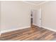 Bedroom featuring wood floors and an open door with partial view of the updated kitchen at 1398 Tarboro Rd, Youngsville, NC 27596