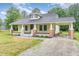 Inviting yellow home featuring a classic design and an attached carport on a gravel driveway at 1398 Tarboro Rd, Youngsville, NC 27596