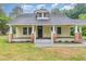 Classic yellow house with a cozy front porch, brick accents, and freshly landscaped flower beds at 1398 Tarboro Rd, Youngsville, NC 27596