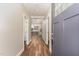 Bright hallway with wood floors and modern gray paint, leading to the kitchen at 1398 Tarboro Rd, Youngsville, NC 27596