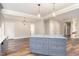 Kitchen island with gray cabinets and granite countertop, open to the living area and brick accent wall at 1398 Tarboro Rd, Youngsville, NC 27596