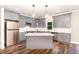 Renovated kitchen featuring gray cabinets, granite countertops, stainless steel appliances, and a central island at 1398 Tarboro Rd, Youngsville, NC 27596