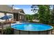 Spacious backyard featuring an above-ground pool, a deck with lounge chairs, and a screened-in porch at 1412 Wakefield Farm Rd, Zebulon, NC 27597
