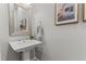 Modern bathroom with pedestal sink, mirror, and neutral decor at 1412 Wakefield Farm Rd, Zebulon, NC 27597