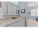 Stylish bathroom with double sinks, granite counters, framed mirror, and a calming blue color scheme at 1412 Wakefield Farm Rd, Zebulon, NC 27597