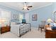 Cozy bedroom with light-blue walls, a black metal bed frame, and wood furnishings at 1412 Wakefield Farm Rd, Zebulon, NC 27597