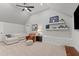 Bright bonus room featuring a sectional couch, a leather chair, and shelves showcasing sports memorabilia at 1412 Wakefield Farm Rd, Zebulon, NC 27597