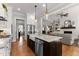 Open-concept kitchen with island, stainless appliances, farmhouse sink, and hardwood floors at 1412 Wakefield Farm Rd, Zebulon, NC 27597