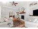 Comfortable living room with fireplace, ceiling fan, rug, and hardwood floors at 1412 Wakefield Farm Rd, Zebulon, NC 27597