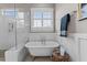 Clawfoot tub situated under a window in a bathroom with wainscoting and a walk-in shower at 1412 Wakefield Farm Rd, Zebulon, NC 27597