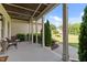 Inviting covered porch with stone columns, wicker furniture, and manicured landscaping at 1412 Wakefield Farm Rd, Zebulon, NC 27597
