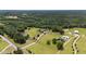 An aerial view showing a home with a pond, a long driveway, and surrounding green space and trees at 14393 Nc Hwy 96 N, Zebulon, NC 27597