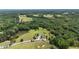 Scenic aerial view of a home situated on a lush, green lot, surrounded by a pond and mature trees at 14393 Nc Hwy 96 N, Zebulon, NC 27597