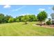 Expansive backyard with lush green grass, mature trees, and a view of the home's exterior at 14393 Nc Hwy 96 N, Zebulon, NC 27597