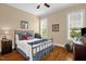 Cozy bedroom features two windows and a metal bed frame over wood floors at 14393 Nc Hwy 96 N, Zebulon, NC 27597