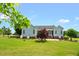 Beautiful home exterior featuring a well-manicured lawn, mature trees, and a charming back patio at 14393 Nc Hwy 96 N, Zebulon, NC 27597
