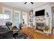 Cozy living room featuring a fireplace, hardwood floors, and abundant natural light at 14393 Nc Hwy 96 N, Zebulon, NC 27597