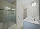 A well-lit bathroom featuring a glass-door shower and double vanity sinks at 1466 Salem Creek Dr, Apex, NC 27502