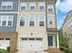 Charming multi-story townhouse with a one-car garage and a beautifully designed facade with varying materials and textures at 1466 Salem Creek Dr, Apex, NC 27502