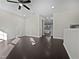An open-concept living room with dark floors and a modern ceiling fan at 1466 Salem Creek Dr, Apex, NC 27502
