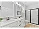Modern bathroom featuring double vanity, sleek fixtures, and a glass-enclosed shower with marble-style tile surround at 154 Buckaroo Dr, Louisburg, NC 27549