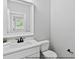 Well-lit half bathroom featuring a white vanity, modern sink, and minimalist fixtures at 154 Buckaroo Dr, Louisburg, NC 27549