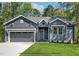 Charming single-story home with gray siding, a two-car garage, and a well-manicured lawn at 154 Buckaroo Dr, Louisburg, NC 27549