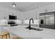 Modern kitchen features white cabinets, quartz countertops, stainless steel appliances, and a large island with a black faucet at 154 Buckaroo Dr, Louisburg, NC 27549
