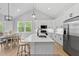 Open concept kitchen with white cabinets, stainless appliances, and a large center island at 154 Buckaroo Dr, Louisburg, NC 27549