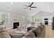 Open-concept living room with a fireplace, vaulted ceilings, and hardwood floors leading to kitchen at 154 Buckaroo Dr, Louisburg, NC 27549