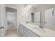 Bright bathroom featuring double vanity with stylish mirrors, ample counter space, and neutral color palette at 1612 Commons Ford Pl, Apex, NC 27539