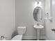 Clean, crisp powder room with modern fixtures including a pedestal sink and ample lighting at 1612 Commons Ford Pl, Apex, NC 27539