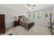 Comfortable bedroom with plush carpet, ceiling fan, and a large window providing natural light at 1612 Commons Ford Pl, Apex, NC 27539