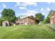 View of the home's backyard, highlighting the shed, fencing, and expansive grassy area at 1641 Regency Dr, Burlington, NC 27215