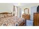 Bright bedroom with floral bedding, natural light, and wood dresser with mirror at 1641 Regency Dr, Burlington, NC 27215
