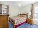 Bedroom with carpet, floral bedding, and a nightstand with lamps for reading at 1641 Regency Dr, Burlington, NC 27215