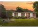 Charming brick home with mature landscaping, a birdbath, and warm sunset hues creating an inviting curb appeal at 1641 Regency Dr, Burlington, NC 27215