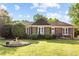 Charming brick home with mature landscaping, a birdbath, and a well-manicured lawn creating an inviting curb appeal at 1641 Regency Dr, Burlington, NC 27215