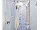 Hallway with blue carpet, neutral walls, and doors leading to various rooms at 1641 Regency Dr, Burlington, NC 27215