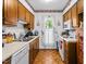 Classic kitchen features wood cabinets, matching appliances, and charming apple themed wallpaper at 1641 Regency Dr, Burlington, NC 27215