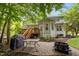 A lovely backyard featuring a deck, patio, a built-in fire pit, and outdoor cooking area, perfect for entertaining at 1702 Mcrae Pl, Hillsborough, NC 27278