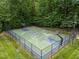 Aerial view of outdoor basketball court with green, blue and white accents and surrounded by a black fence at 1702 Mcrae Pl, Hillsborough, NC 27278