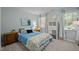 Bedroom with a queen bed, wooden dresser, cube storage, and abundant natural light from two windows at 1702 Mcrae Pl, Hillsborough, NC 27278