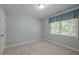 A bright bedroom with neutral carpet and a window with natural light coming through blinds at 1702 Mcrae Pl, Hillsborough, NC 27278