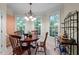 Cozy dining area features a round table, chandelier, and plenty of natural light from large windows at 1702 Mcrae Pl, Hillsborough, NC 27278